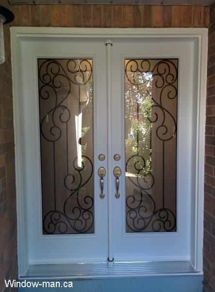 Double steel insulated front entry doors. White. Full wrought iron glass door inserts. Gateway wrought iron glass inserts